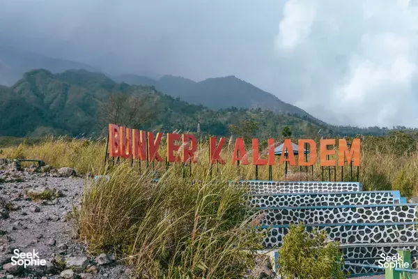 Bunker Kali Adem sign by stone steps with misty mountains in the background during Mount Merapi adventure in Yogyakarta