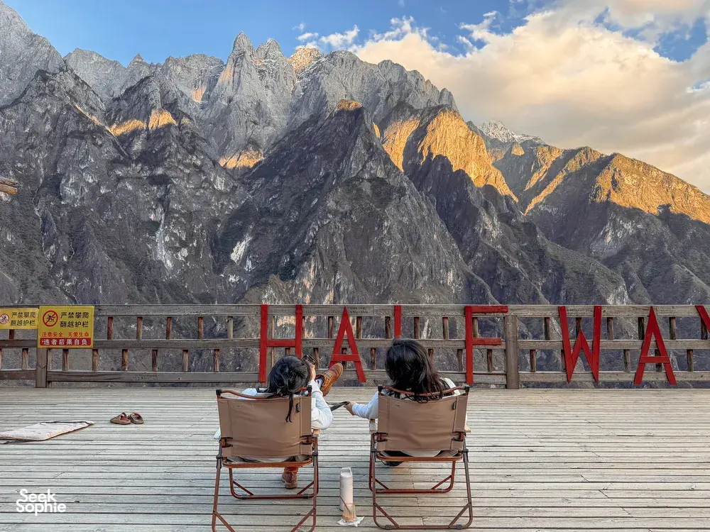 Travellers seated at a mountain viewpoint over steep peaks on the 2D1N Lesser-Known High Trail of Tiger Leaping Gorge, Lijiang