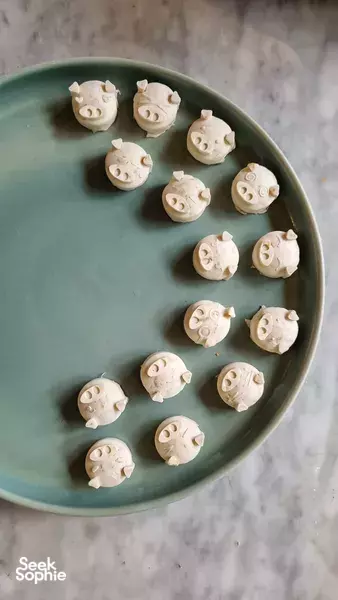 Close-up of homemade tempe cookies cooling on a green plate, showing small molded shapes ready to taste