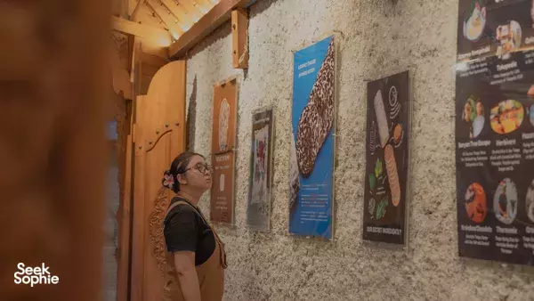 Visitor reading tempe posters in a Bali TempeGo Experience room before learning traditional tempe making