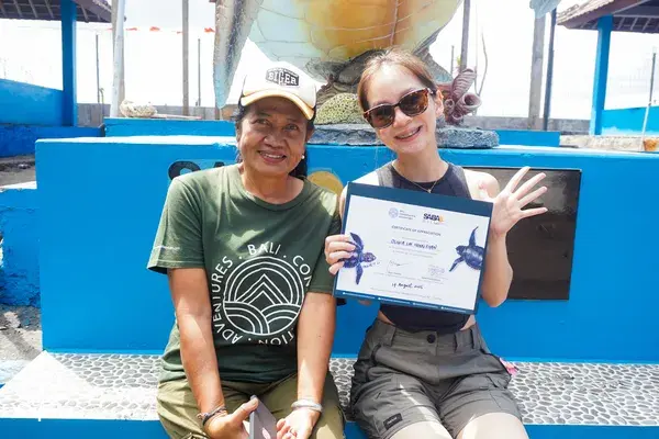 Certificate moment at a Bali sea turtle conservation centre with Bali Conservation Adventures, two participants seated beside a pool