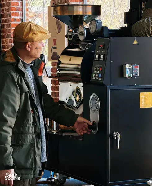 Seeker Yunnan Coffee Estate host operating a commercial coffee roaster in Lijiang, sampling and controlling roasting for specialty