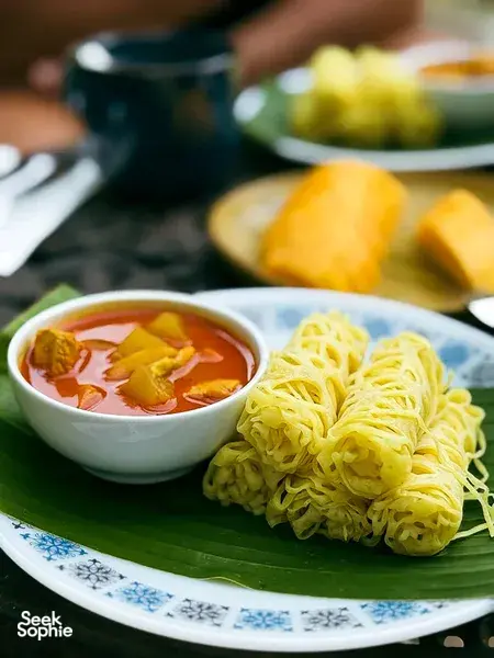 Bowls of Malaysian curry with noodles on a banana leaf at Kebun Lidstari farmhouse dining in Langkawi