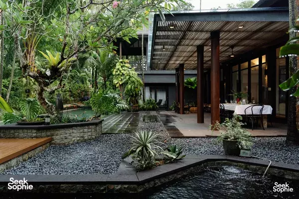 Rainforest garden courtyard with a reflecting pond, stone paths and a covered dining area in a villa in Singapore for private dining Singapore