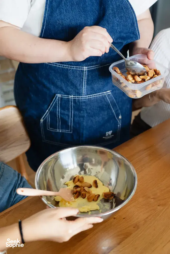 Hands mixing flavoured butter with chopped fillings in a bowl for shio pan baking during hands-on workshops in Singapore