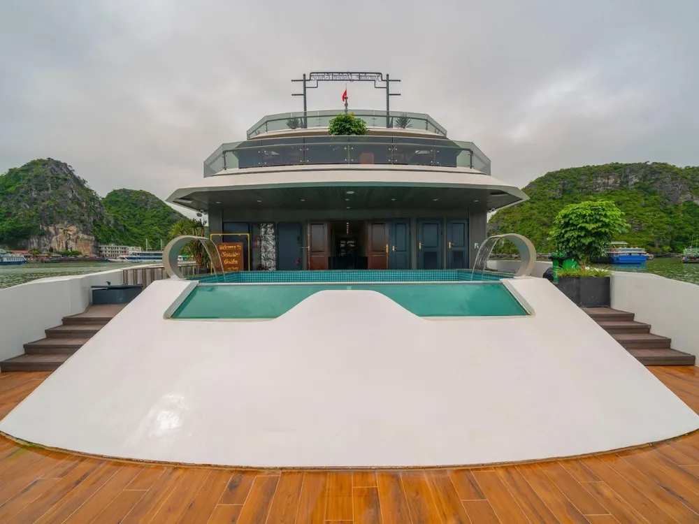 Sun deck hot tub on a Cat Ba 2D1N luxe cruise, with the ship’s upper lounge behind and green limestone bay scenery