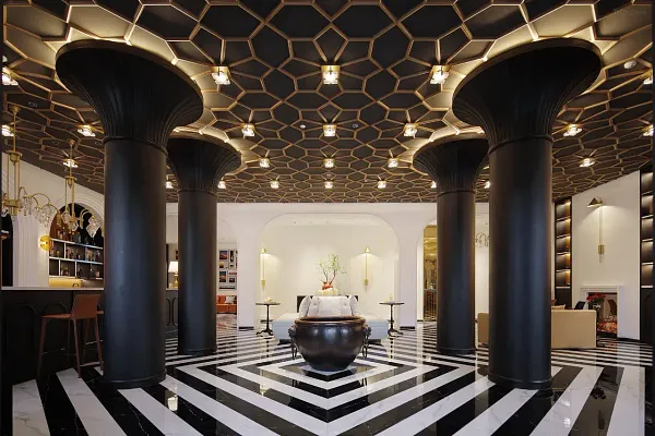 The Bivou Lijiang lobby in Shuhe Ancient Town, Lijiang, with black columns, hexagonal ceiling lights and a central urn