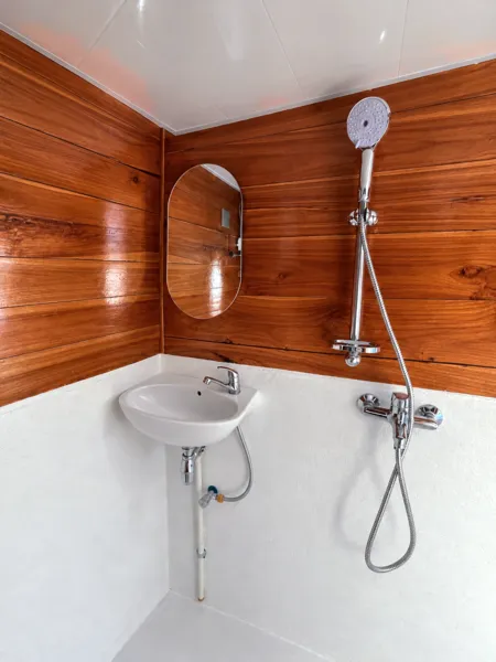 Wooden phinisi en-suite bathroom with round sink and shower fixtures on a 3D2N Komodo cruise, Labuan Bajo