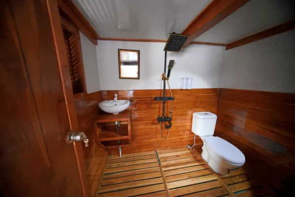 Private bathroom on a wooden boat for a 3D2N join-in Komodo trip, with toilet, sink, and shower, near Komodo Island