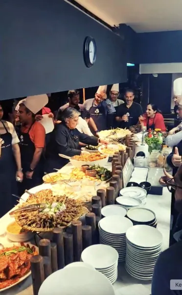 Team guests gather around buffet platters and stacked plates during local produce cooking challenge workshops in Singapore