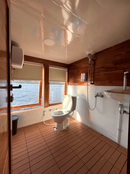 Onboard bathroom with toilet and sink on a wooden phinisi for a 3D2N shared Komodo cruise, hosted by La Famille in Labuan Bajo