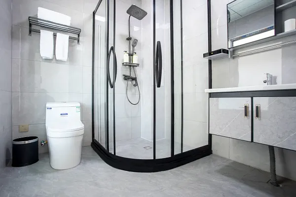 Modern en suite bathroom at The Bivou Lijiang with glass shower, toilet, and vanity sink, designed for comfortable trekking 2D1N