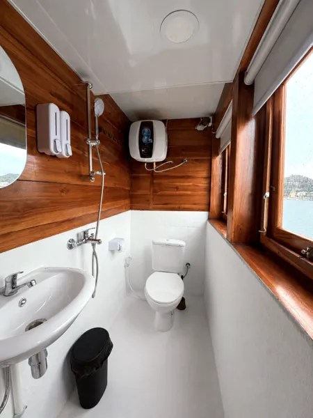 Compact en-suite bathroom on a wooden phinisi with sink, shower fixtures and toilet on a 3D2N shared cruise to Komodo Island
