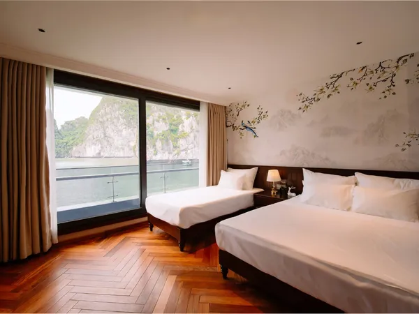 Sunshine Golden Cruises Cat Ba cruise cabin with two twin beds, wooden floors and floor-to-ceiling window over the bay