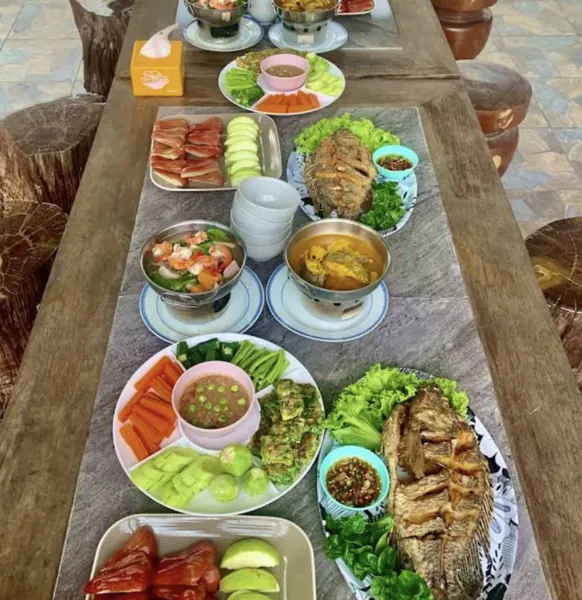 Thai buffet meal spread on a wooden table with soups and fresh veg during a private Khao Sok escape in Khao Sok National Park