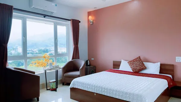 Sunlit guest bedroom in Cao Bang with a double bed near a large window, part of the 3D3N motorbike loop stay