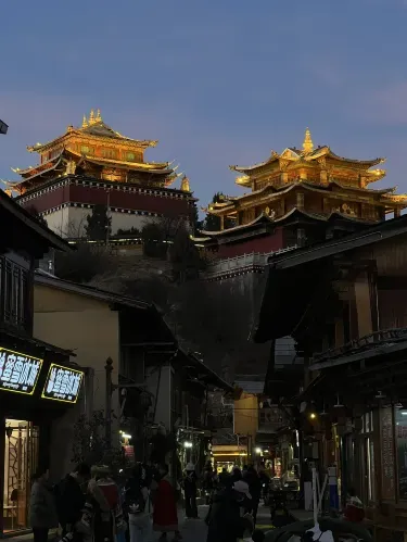 Lantern-lit street in Shuhe Ancient Town, Lijiang, with traditional Naxi buildings and gold-roofed architecture outside The Bivou Lijiang