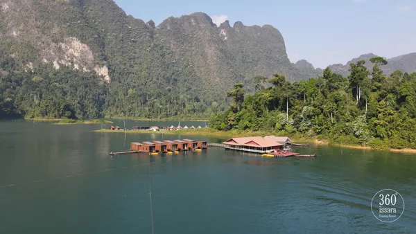 考索国家公园橙顶水上平房的湖畔景色,四周是青翠的喀斯特山峦,沿着秀兰湖展开