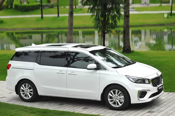 White Mui Ne Private Car parked on a walkway in a green garden, ready for a Ho Chi Minh City to Mekong transfer