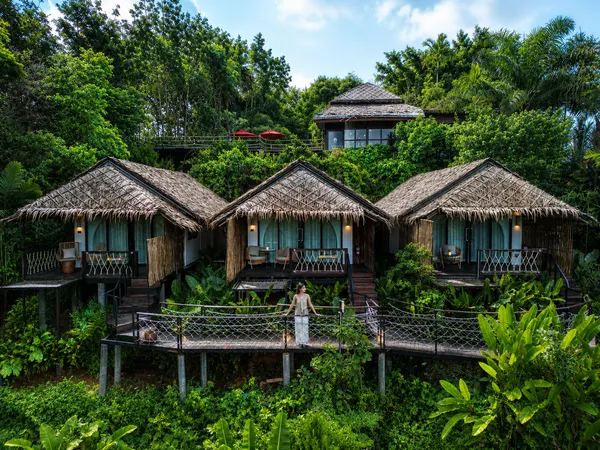 Khaosok Discovery 打造的茂密绿意中的茅草顶豪华露营小屋,位于考索国家公园,配有木栈道