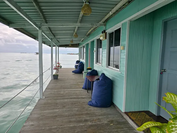 Dek banglo air di Semporna dengan bean bag biru dan tingkap menghadap laut semasa penginapan 2H1M di Bigfin Divers
