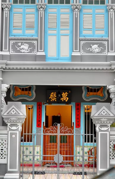 Ornate Joo Chiat shophouse front with decorative blue shutters and gold Chinese characters above the entrance, Singapore hidden gems