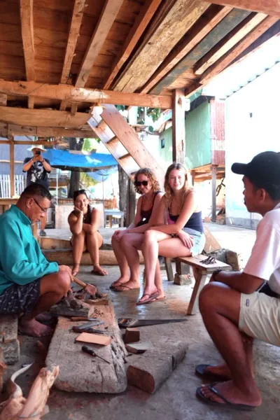 Para pelancong bersantai di area lounge beratap di phinisi Leticia Liveaboard selama perjalanan Komodo di Labuan Bajo