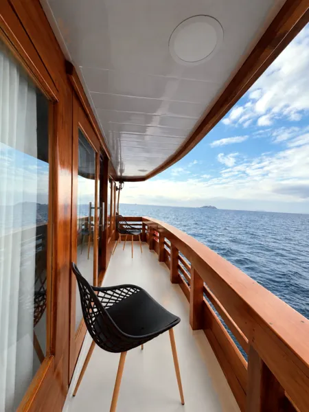 Wooden phinisi deck with chairs and panoramic ocean horizon on a 3D2N shared cruise from Labuan Bajo, Komodo Island