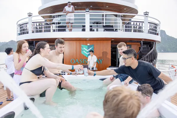 Guests mingle in the pool on the Oasis Bay Party Cruiser during a lively Halong Bay party cruise