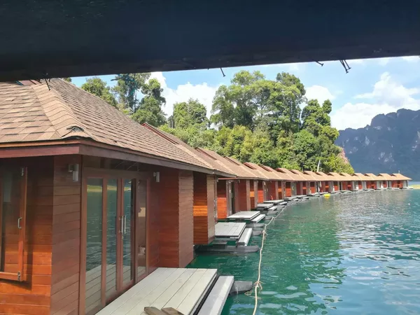 Timber glamping cabins on a stilted walkway beside Cheow Lan Lake in Khao Sok National Park—Khaosok Discovery stay