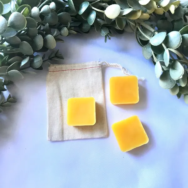 Yellow beeswax food wrap squares on a cloth with eucalyptus leaves, ready to reuse at Agrihome workshops in Singapore