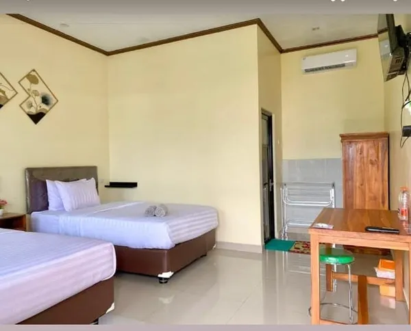Kamar tamu sederhana dengan dua tempat tidur dan AC, bagian dari titik singgah perjalanan 5H4M ke Bromo, Tumpak Sewu, dan Ijen di Surabaya