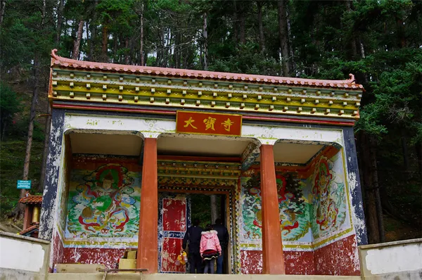 Visitors pause at the 大觉寺 gate on a Tibetan Valley Day Trek with Mission Liotard near Shangri-La in Yunnan’s forest