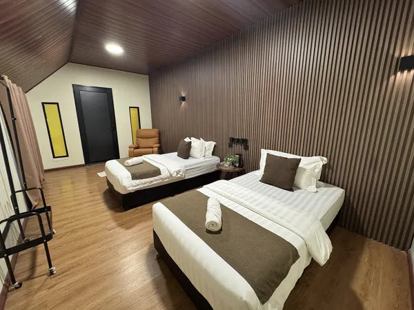 Two neatly made beds and coffee tray in Sukau Greenview Lodge room for a 2D1N safari in Sandakan along the Kinabatangan River