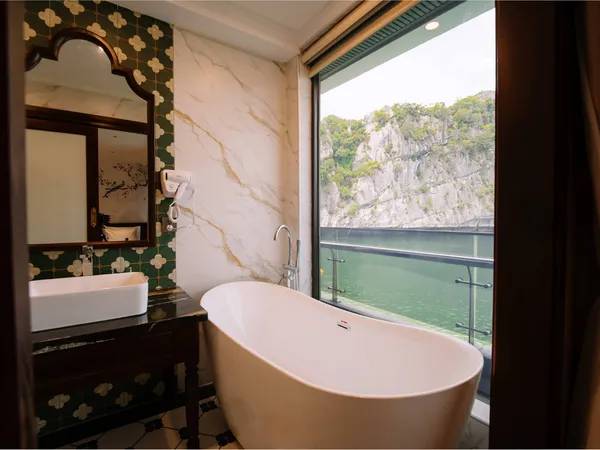 Private on-board bath on a 2D1N Cat Ba cruise with Sunshine Golden Cruises, overlooking calm green water and limestone cliffs