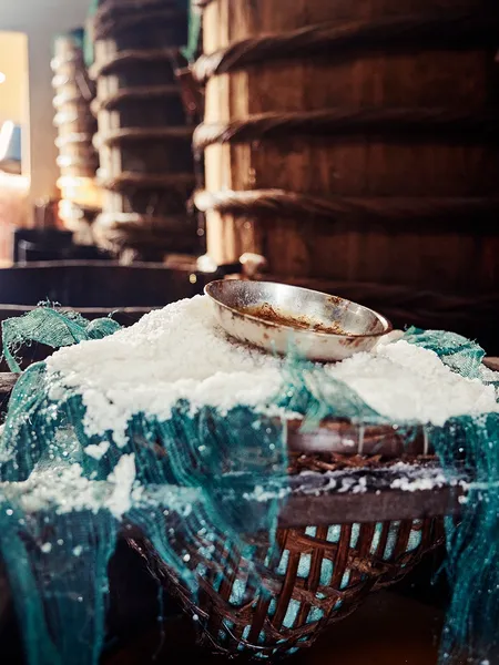 Salt-making setup with a metal bowl in a woven basket in Hoi An, an ancient trades stop on the morning motorbike tour