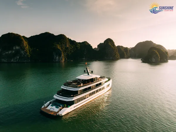 Sunshine Golden Cruises cruise ship gliding through Cat Ba waters at sunset, past limestone islands on a 2D1N getaway