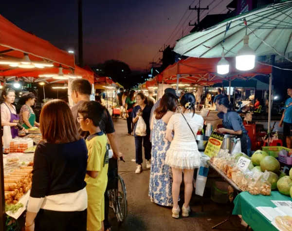 Crowded night market in Khao Yai with food stalls and shoppers, part of the trek’s lunch and dinner experience