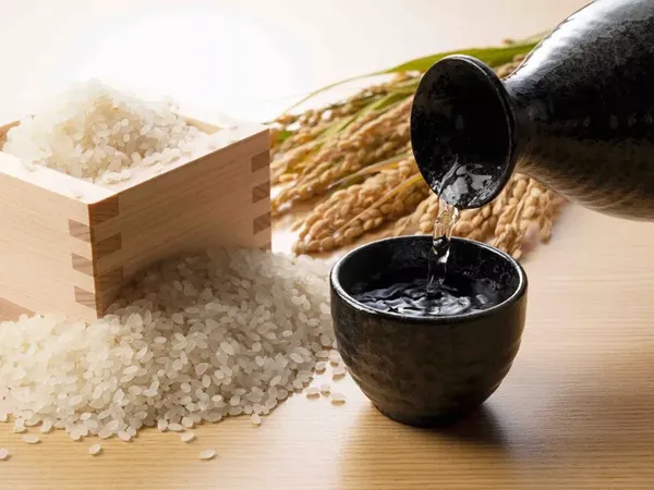Water poured into a cup beside rice grains during a 2D1N cruise with Bhaya Group to Viet Hai Village in Halong Bay