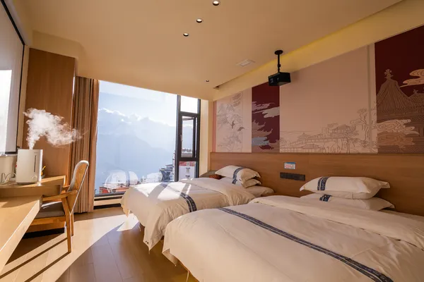 Sunlit bedroom with wide windows and mountain views, part of a 6-day Shangri-La Loop with a Tibetan guide