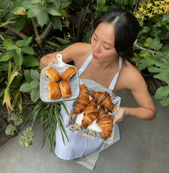 French Cooking Lab host presenting baked croissants from a tray at a Singapore croissant baking workshop — workshops in Singapore