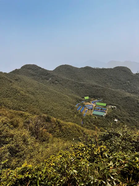 Hikers on a narrow ridge trail above Sapa, trekking the Fansipan mountains on a plastic-free eco day hike with local guidance