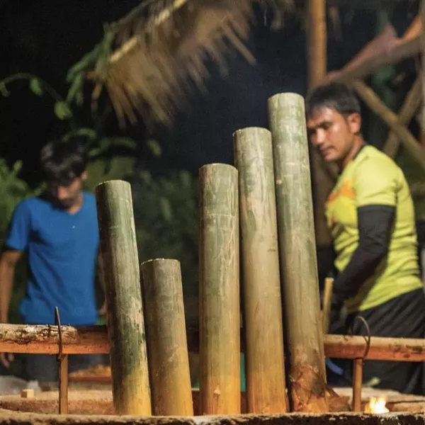 Bamboo grilling or dining setup outdoors with guests chatting at night, part of Anurak Lodge’s eco-retreat in Khao Sok National Park.