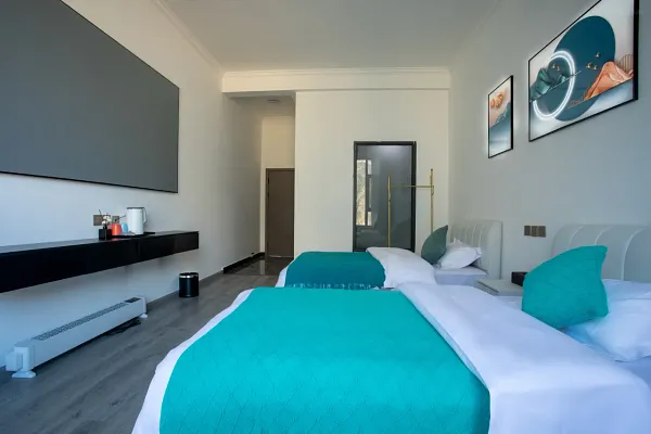 The Bivou Lijiang boutique room with twin beds, turquoise bedding and Naxi-style décor, set near Shuhe Ancient Town courtyards