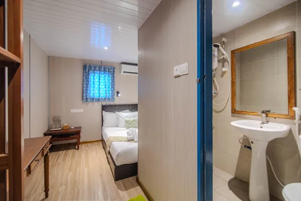 Double bed cabin with en-suite sink and shower door on Seaventures Dive Rig offshore stay near Semporna, Sabah