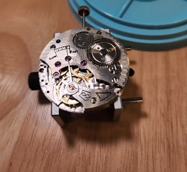 Close-up of a mechanical watch movement on a wooden bench during a build-your-own watchmaking session in Singapore — workshops in Singapore
