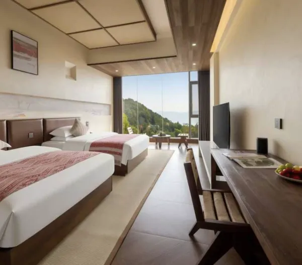 Twin- and double-bed guest room in Xishuangbanna tea lodge, with floor-to-ceiling windows and a small dining table