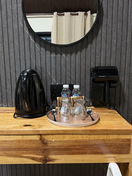 Coffee and tea station with electric kettle and bottled drinks on a wooden counter in Sukau Greenview Lodge, Kinabatangan River