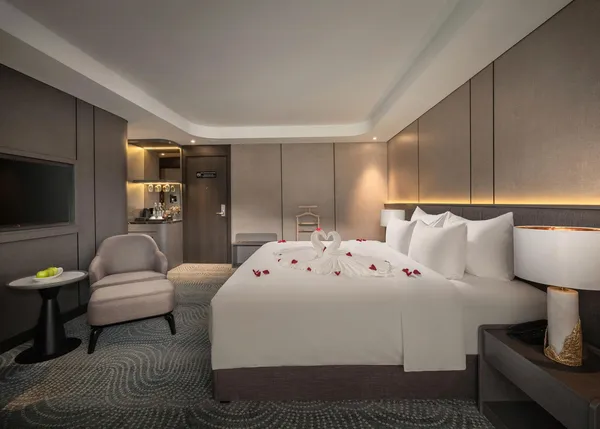 Kabin kapal pesiar Tulip dengan tempat tidur double berhias angsa dari handuk, kursi santai, dan area minuman di Teluk Halong