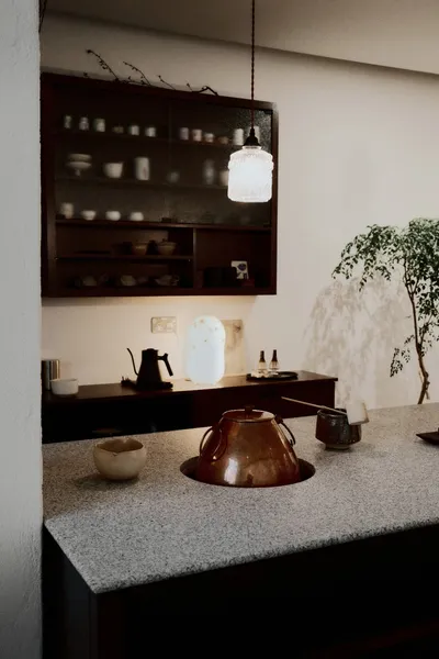 Teapot, cups and spice jars on a café counter beside a small plant, a Joo Chiat stop in Singapore